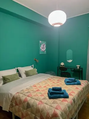 a bedroom with a large bed with blue walls at The Green Apartment Athens in Athens