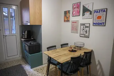 a small kitchen with a wooden table and chairs at The Green Apartment Athens in Athens