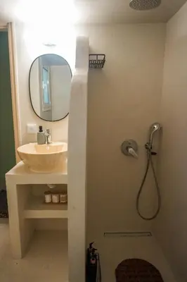 a bathroom with a sink and a shower with a mirror at The Green Apartment Athens in Athens