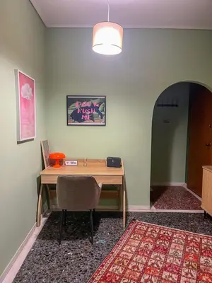 a room with a wooden table with chairs and a rug at The Green Apartment Athens in Athens