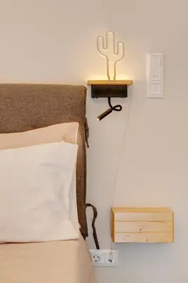 a bedroom with a bed with a cactus on a night stand at Rafael Apartment Ampelokipoi in Athens