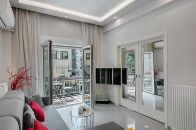 a living room with a couch and a tv at Rafael Apartment Ampelokipoi in Athens