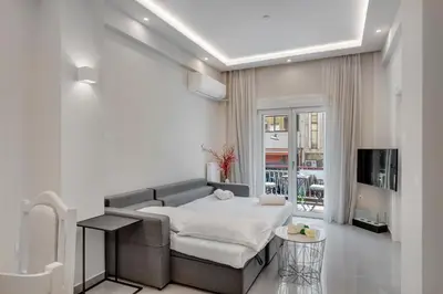 a living room with a bed and a tv at Rafael Apartment Ampelokipoi in Athens