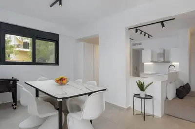 a dining room with a table and white chairs at Athenian Black Villa in Saronida