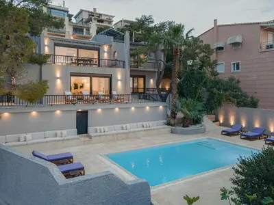 a villa with a swimming pool in front of a building at Athenian Black Villa in Saronida