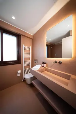 a bathroom with a toilet and a large mirror at Ikima Living in Piraeus