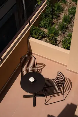 a chair sitting on a balcony with a table at Ikima Living in Piraeus