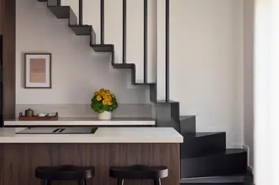 a kitchen with a counter with stools and stairs at Ikima Living in Piraeus