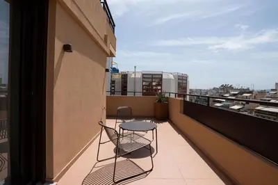 a balcony with two chairs and a table on a building at Ikima Living in Piraeus