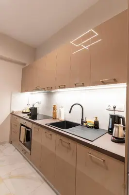 a kitchen with brown cabinets and a sink at Athenian Secret Key Residence in Athens