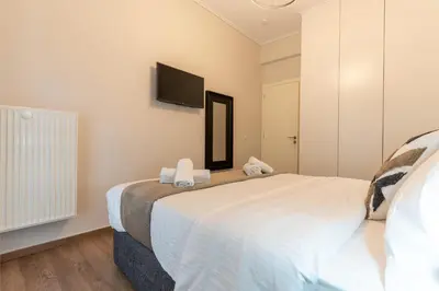 a bedroom with a large bed with a tv on the wall at Athenian Secret Key Residence in Athens