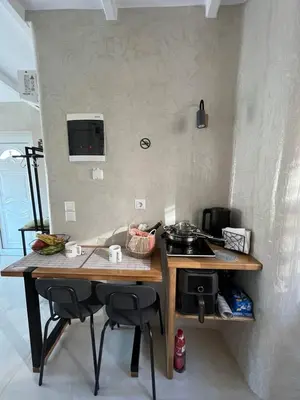 a kitchen with a table with two chairs and a stove at Boutique Eptalofos 2 15min from airport and sea in Kouvarás