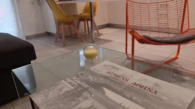 a glass table with a wine glass and a magazine at Kypseli is a Mood in Athens