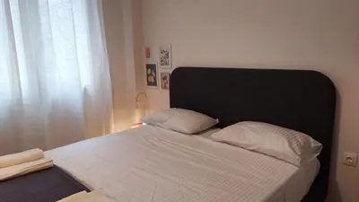 a bed with a black headboard in a bedroom at Kypseli is a Mood in Athens