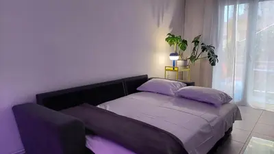 a bed in a bedroom with a plant next to a window at Kypseli is a Mood in Athens