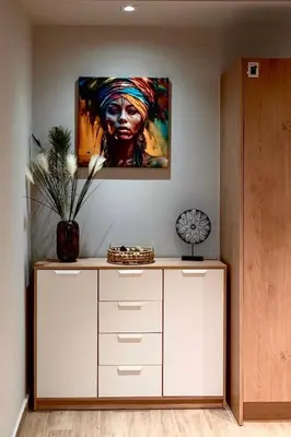 a painting of a black woman hanging on a wall at African Adventure Apartment in Piraeus