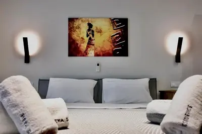 a bedroom with a bed and a painting on the wall at African Adventure Apartment in Piraeus