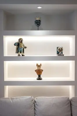 a living room with white shelves with figurines on them at Big London Apartment in Piraeus in Piraeus