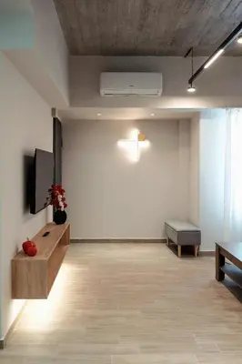 an empty room with a tv and a bench at Big London Apartment in Piraeus in Piraeus