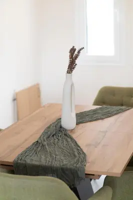 a white vase sitting on top of a wooden table at Airport city center 4 in Spáta