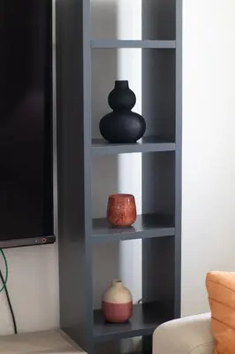 a book shelf with vases and a tv at Airport city center 4 in Spáta