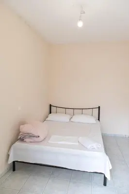 a bed with white sheets and pillows in a room at Airport city center 4 in Spáta