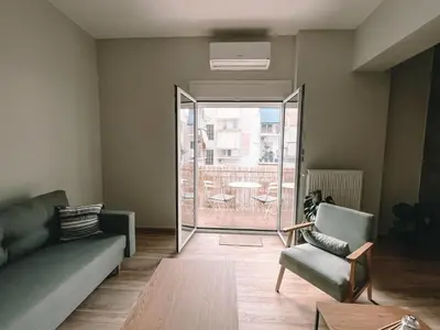 a living room with a couch and a glass door at Sunlit luxurious flat at pagrati! in Athens