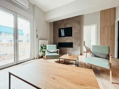 a living room with two chairs and a tv at Sunlit luxurious flat at pagrati! in Athens