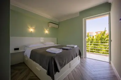 a bedroom with a large bed and a large window at MORE Apartments in Áyios Yeóryios