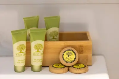 a wooden box with three bottles of olive tree soap at MORE Apartments in Áyios Yeóryios