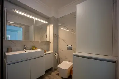 a bathroom with a sink and a toilet and a mirror at MORE Apartments in Áyios Yeóryios
