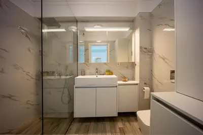 a bathroom with a sink and a toilet and a mirror at MORE Apartments in Áyios Yeóryios