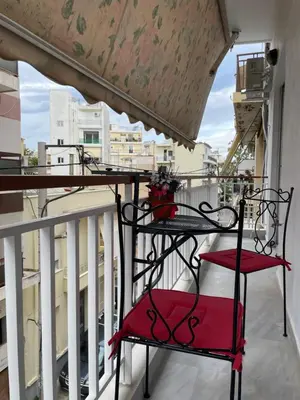 a balcony with two red chairs on a balcony at Kolonos Comfort Design Flat for Easy City Living in Athens