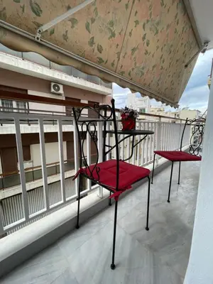 two red chairs sitting on a balcony at Kolonos Comfort Design Flat for Easy City Living in Athens