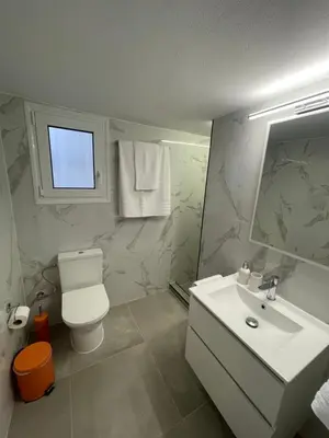 a bathroom with a sink and a toilet and a window at Kolonos Comfort Design Flat for Easy City Living in Athens