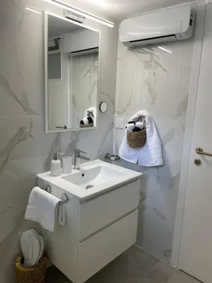 a white bathroom with a sink and a mirror at Kolonos Comfort Design Flat for Easy City Living in Athens