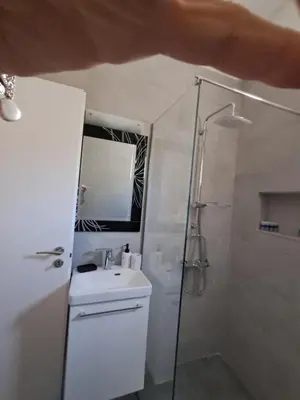 a white bathroom with a shower and a sink at Reina in Athens