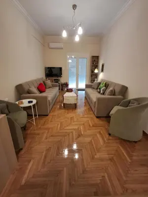 a living room with two couches and a wooden floor at Reina in Athens