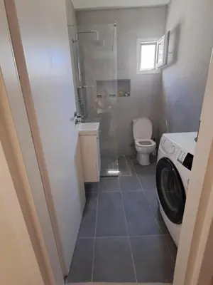 a bathroom with a shower and a washing machine at Reina in Athens