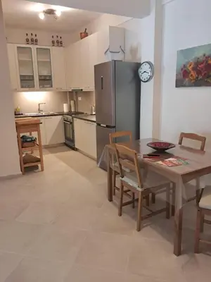 a kitchen and dining room with a table and a refrigerator at Reina in Athens