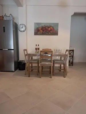 a kitchen with a table and chairs and a refrigerator at Reina in Athens
