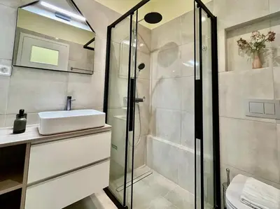 a bathroom with a glass shower and a sink at Home away from home in Athens
