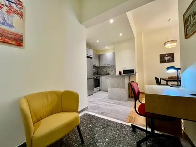 a living room with a yellow chair and a desk at Home away from home in Athens