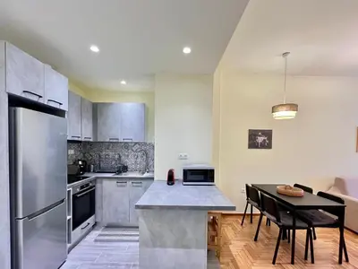 a kitchen with a stainless steel refrigerator and a table at Home away from home in Athens