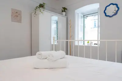 two towels sitting on top of a white bed at The Psyri Collection in Athens