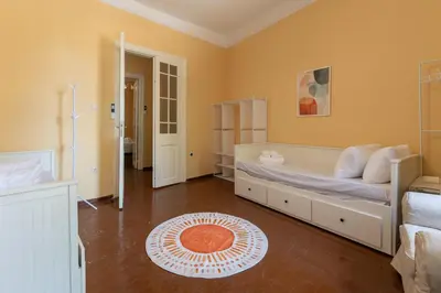 a bedroom with a white bed and a orange wall at The Psyri Collection in Athens
