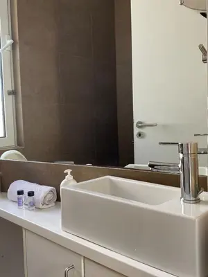 a bathroom with a white sink and a mirror at Ermou 44 - Studio - Acropolis view in Athens