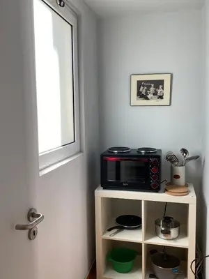 a microwave on a stand in a room with a window at Ermou 44 - Studio - Acropolis view in Athens