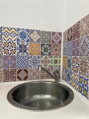 a bathroom with a sink and tiles on the wall at Ermou 44 - Studio - Acropolis view in Athens