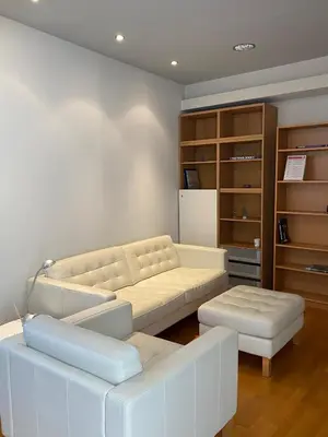 a living room with a white couch and ottoman at Ermou 44 - Studio - Acropolis view in Athens